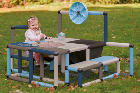 Child playing with sand on a play table